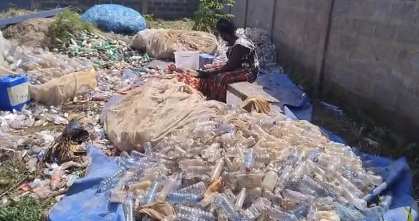 Worker sorting recovered plastic bottles by resin type at the Plastoss yard
