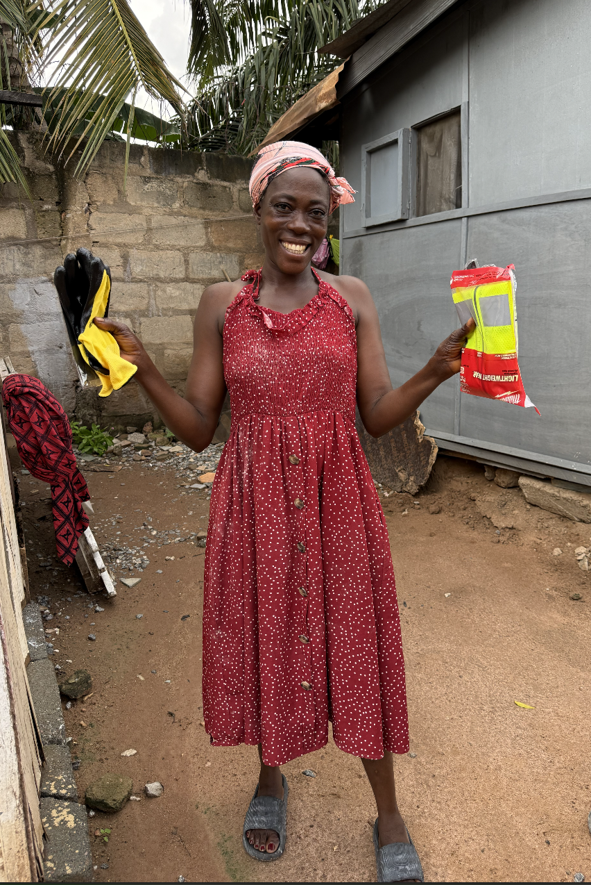 Faustina holding her new PPE gloves and safety vest