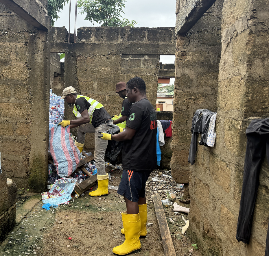 Collectors in PPE sorting bottles inside a walled yard